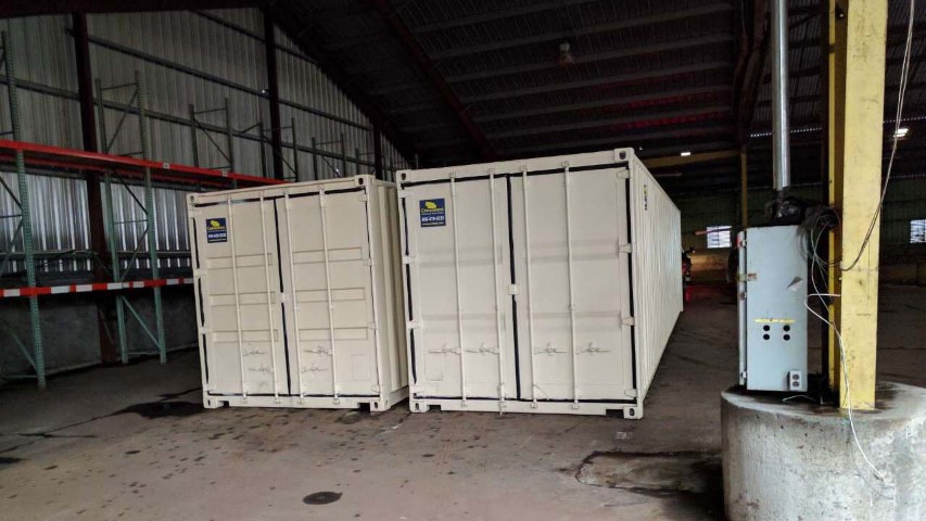 double storage container shipping container with cargo doors conexwest sign inside factory facility 