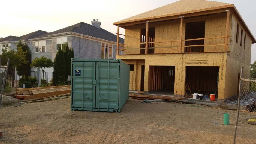 contracted use shipping container storage container on site rebuilding house house frame green color storage container grey sky