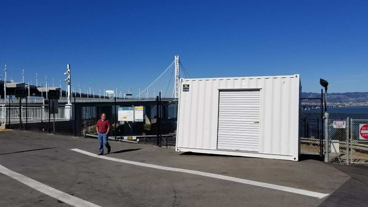 shipping container roll up door blue sky bay bridge San Francisco California 