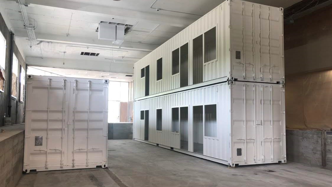 dual stacked shipping containers inside of warehouse