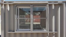 Barn door window security for storage container for sale